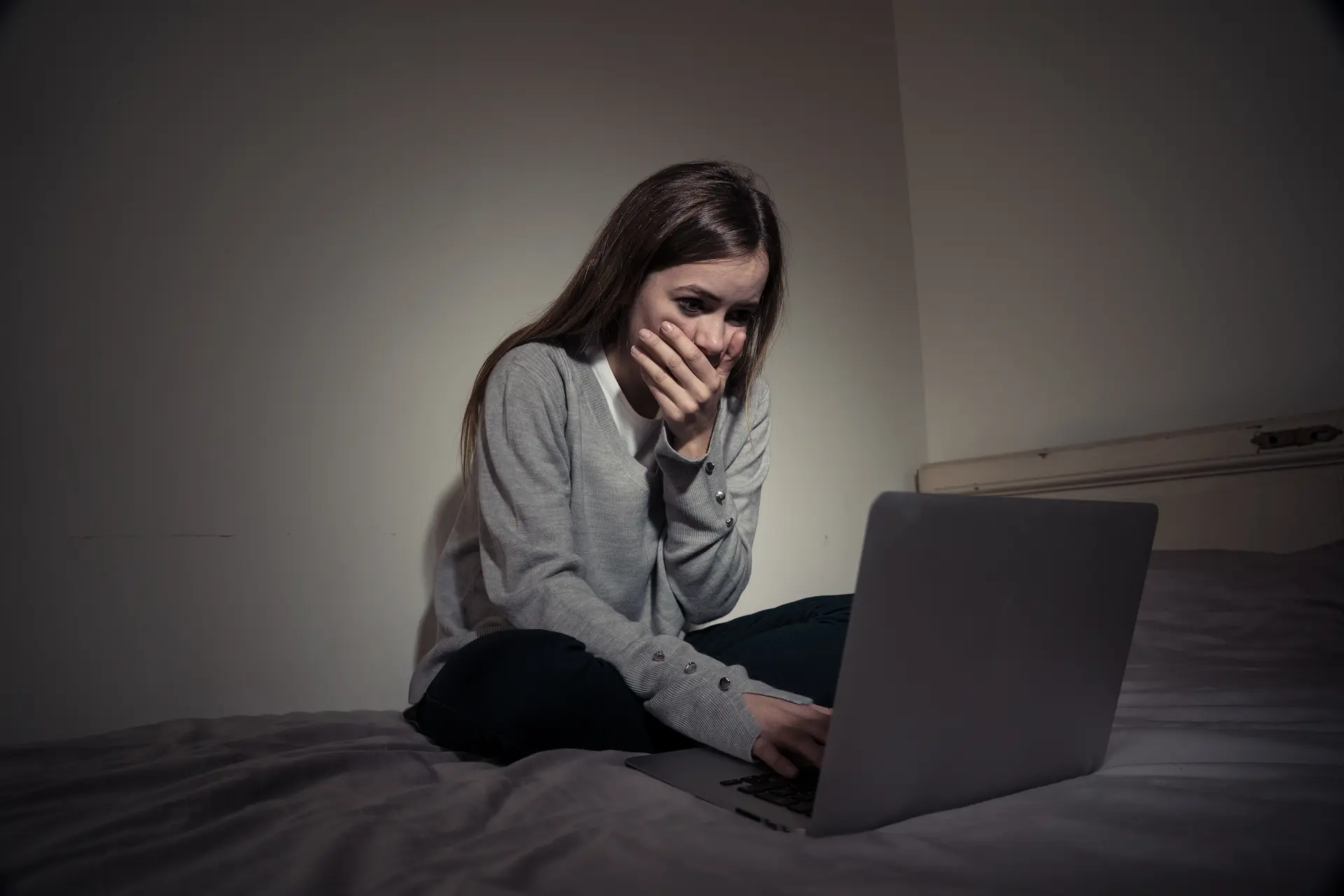 Representación visual de un niño o niña frente a una pantalla con símbolos de alerta y protección, enfatizando la importancia de la supervisión y la seguridad online.