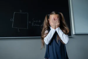 Niños en patio escolar con adulto, ilustrando la omisión y sanciones a colegios por acoso escolar
